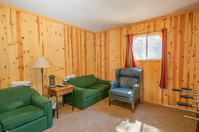 a living room with two chairs and a couch and a window at Big Bear Retreat - A charming mountain cabin with easy access to Big Bear's attractions! in Big Bear Lake