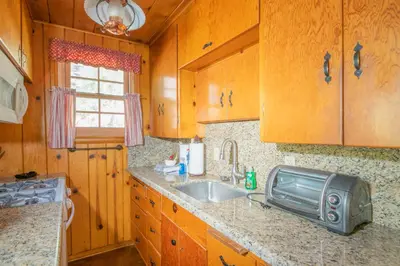 a kitchen with a sink and a microwave at Big Bear Retreat - A charming mountain cabin with easy access to Big Bear's attractions! in Big Bear Lake