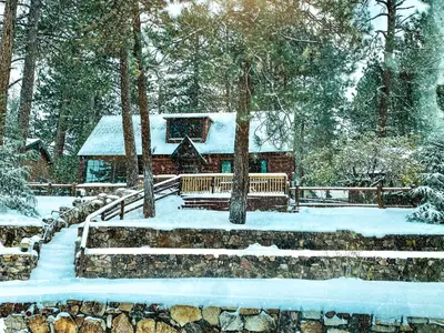 a cabin in the woods with snow on the ground at Big Bear Retreat - A charming mountain cabin with easy access to Big Bear's attractions! in Big Bear Lake
