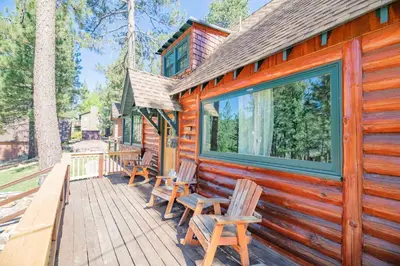 a cabin with benches on a wooden deck at Big Bear Retreat - A charming mountain cabin with easy access to Big Bear's attractions! in Big Bear Lake