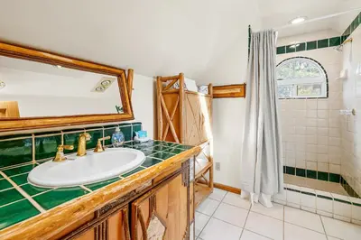 a bathroom with a sink and a mirror at Blue Lagoon - Classic Lakefront Cabin with Pool Table! in Big Bear Lake