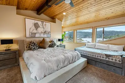a bedroom with two beds and a desk and windows at Boulder Bay Chalet Lakefront - Elegantly decorated with Hot Tub and Game Room! in Big Bear Lake