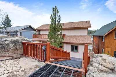 a deck with solar panels in front of a house at Boulder Bay Chalet Lakefront - Elegantly decorated with Hot Tub and Game Room! in Big Bear Lake