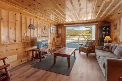 a living room with a couch and a table at Boulder Bay Lakefront Getaway - Across the street from the lake and Boulder Bay Park! in Big Bear Lake