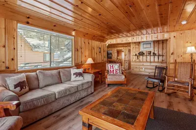 a living room with a couch and a table at Boulder Bay Lakefront Getaway - Across the street from the lake and Boulder Bay Park! in Big Bear Lake
