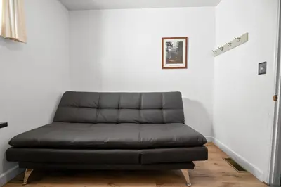 a black couch in a room with a white wall at Boulder Bay Lakefront Getaway - Across the street from the lake and Boulder Bay Park! in Big Bear Lake