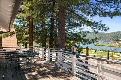 a deck with a table and chairs and a tree at Boulder Bay Lakefront Getaway - Across the street from the lake and Boulder Bay Park! in Big Bear Lake