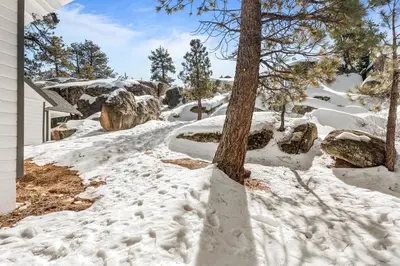 a driveway covered in snow next to a house at Boulder Bay Lakefront Getaway - Across the street from the lake and Boulder Bay Park! in Big Bear Lake