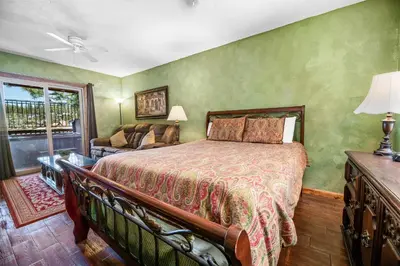 a bedroom with a bed and a couch and a window at Boulder Bay Park Lakefront - Across the street from the lake and Boulder Bay Park! Hot tub! in Big Bear Lake