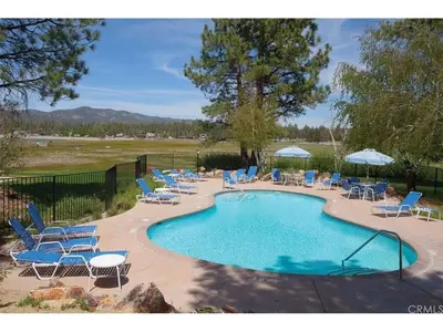 a swimming pool with lounge chairs and a bunch ofitures at Brown Bear's Den - Spacious condo within walking distance to all Big Bear has to offer! in Big Bear Lake
