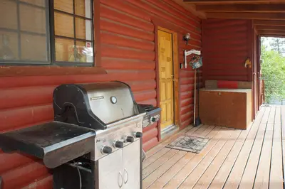 a stove on the outside of a house with a porch at Canyon Cabin - A quaint cabin in a peaceful location yet close to Big Bear's attractions! in Fawnskin