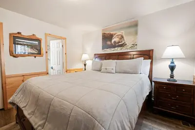 a bedroom with a large bed and two lamps at Catalina Creekside Cabin - Log home with wood burning fireplace for an immersive mountain getaway! in Big Bear Lake