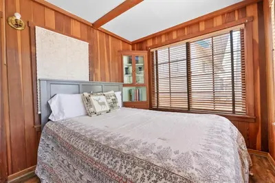 a bedroom with a bed with wooden walls and a window at Chalet Des Ours -Comfortable and spacious home with WIFI! Close to everything! in Big Bear Lake