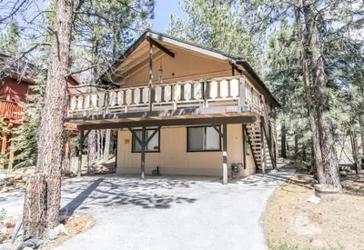 a cabin in the woods with a tree at Chalet Georgia - Spacious and cozy home, conveniently close to the heart of Big Bear! in Big Bear Lake