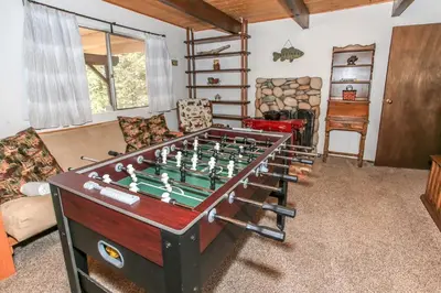 a living room with a foosball table at Chalet Georgia - Spacious and cozy home, conveniently close to the heart of Big Bear! in Big Bear Lake