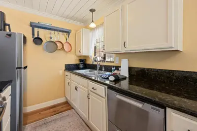 a kitchen with white cabinets and a sink at Chipmunk House - Magical Boulder Bay cottage within a picturesque setting! in Big Bear Lake