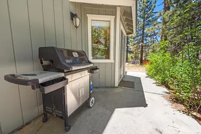 a grill is sitting outside of a house at Cub Run Cabin - Spacious home close to the lake with Hot tub! in Big Bear Lake