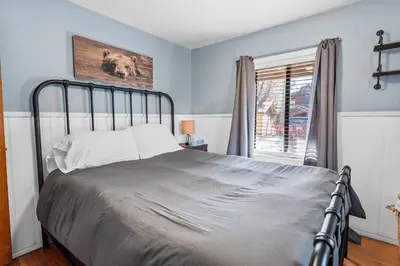 a bedroom with a bed and a window at Dream Street Escape -Private Hot Tub, near the Village and Lake! in Big Bear Lake