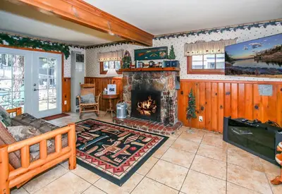 a living room with a fireplace and a couch at Eagle's Den - Cozy cabin with a beautiful wood burning fireplace! Foosball Table! in Big Bear Lake