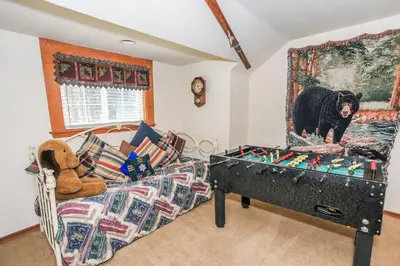 a living room with a bear painting on the wall at Eagle's Den - Cozy cabin with a beautiful wood burning fireplace! Foosball Table! in Big Bear Lake