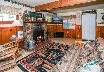 a living room with a couch and a fireplace at Eagle's Den - Cozy cabin with a beautiful wood burning fireplace! Foosball Table! in Big Bear Lake
