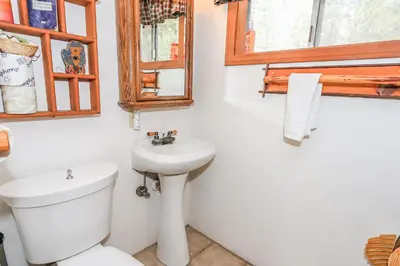 a white bathroom with a toilet and a sink at Eagle's Den - Cozy cabin with a beautiful wood burning fireplace! Foosball Table! in Big Bear Lake