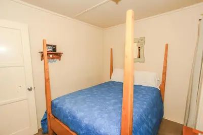a bedroom with a bunk bed with a blue comforter at Eagle's Den - Cozy cabin with a beautiful wood burning fireplace! Foosball Table! in Big Bear Lake