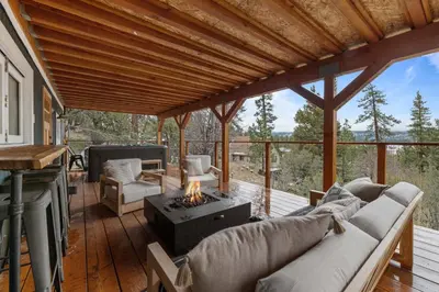 a screened in porch with a couch and a fireplace at Enchanted Hideaway - Newly remodeled with Hot Tub and Lake Views! in Fawnskin