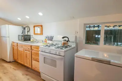 a kitchen with a stove and a white refrigerator at Evergreen Paradise - Beautiful newly remodeled cabin with Hot Tub and Game Room! in Big Bear Lake