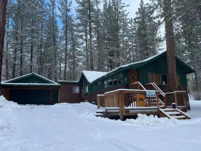 a cabin in the woods with snow on the ground at Evergreen Paradise - Beautiful newly remodeled cabin with Hot Tub and Game Room! in Big Bear Lake
