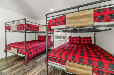 a bedroom with two bunk beds in a house at Family Fun Cabin - Mountain home with Game Room, Hot Tub and Lake Views! in Fawnskin