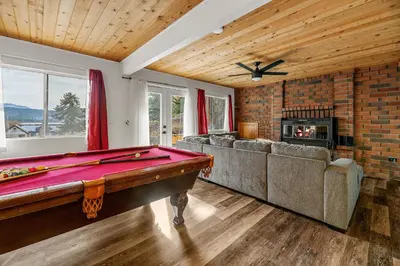 a living room with a pool table and a fireplace at Family Fun Cabin - Mountain home with Game Room, Hot Tub and Lake Views! in Fawnskin