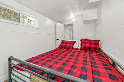 a red and black checkered bed in a room at Family Fun Cabin - Mountain home with Game Room, Hot Tub and Lake Views! in Fawnskin