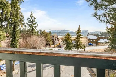 a view of a town from a wooden railing at Family Fun Cabin - Mountain home with Game Room, Hot Tub and Lake Views! in Fawnskin