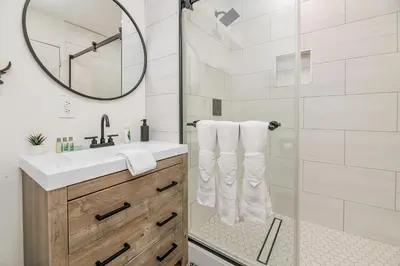 a bathroom with a shower with a sink and a mirror at Family Fun Cabin - Mountain home with Game Room, Hot Tub and Lake Views! in Fawnskin
