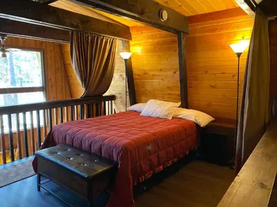 a bedroom with a bed in a log cabin at Fanciful Winter's Lake - Mix of old-world charm and modern-day gambrel style cabin! in Big Bear Lake