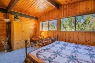 a bedroom with a bed in a log cabin at Fawnskin Family Cabin - Nicely decorated cabin with a lake view and a Foosball Table! in Fawnskin