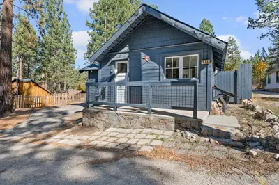 a blue tiny house with a fence at Finns Fish Camp - Walking distance to Lake and Village! Back patio with barbecue, fully fenced yard! in Big Bear Lake