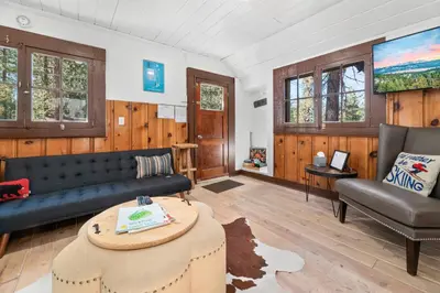 a living room with a couch and a table at Finns Fish Camp - Walking distance to Lake and Village! Back patio with barbecue, fully fenced yard! in Big Bear Lake