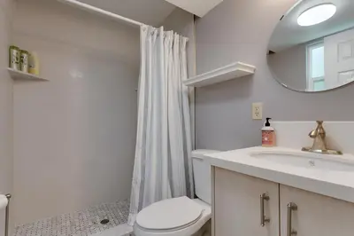a bathroom with a toilet and a sink and a mirror at Five Pines - Beautifully remodeled gambrel cabin with Hot Tub and Fenced Yard! in Big Bear Lake