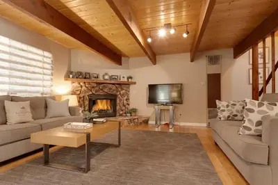 a living room with a couch and a fireplace at Five Pines - Beautifully remodeled gambrel cabin with Hot Tub and Fenced Yard! in Big Bear Lake