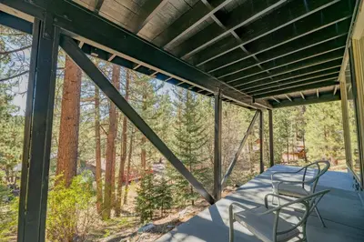 a screened in porch with a table and chairs on it at Forest Escape - Situated on the quiet side of the lake, nicely decorated contemporary cabin! in Fawnskin