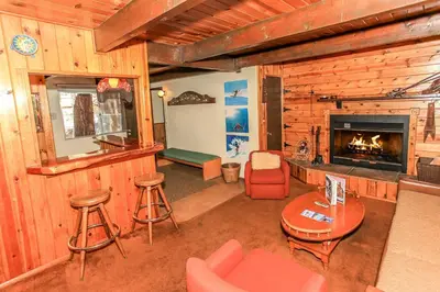 a living room with a fireplace in a log cabin at Gallagher's West - Pine surrounded deck and barbecue! Bumper Pool and Wet bar! Darts! in Big Bear Lake