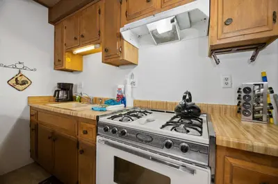 a kitchen with a stove and a white oven at Glenview Getaway - Cozy farm house! Walking distance to the lake! in Big Bear Lake