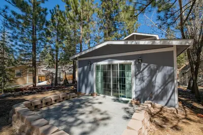 a house with a glass door in a yard at Glenview Getaway - Cozy farm house! Walking distance to the lake! in Big Bear Lake