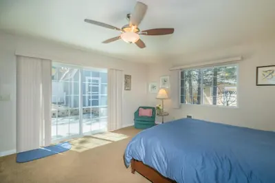 a bedroom with a blue bed and a ceiling fan at Glenview Getaway - Cozy farm house! Walking distance to the lake! in Big Bear Lake