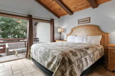 a bedroom with a bed and a balcony at Hakuna Matata Lakefront - LAKEFRONT, PRIVATE DOCK, AND GAME ROOM! in Big Bear Lake
