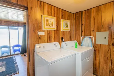 a washer and dryer in a room with wooden walls at Hakuna Matata Lakefront - LAKEFRONT, PRIVATE DOCK, AND GAME ROOM! in Big Bear Lake