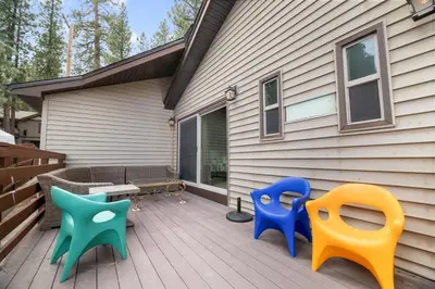 a deck with three chairs and a table on a house at Hakuna Matata Lakefront - LAKEFRONT, PRIVATE DOCK, AND GAME ROOM! in Big Bear Lake