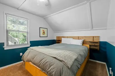 a bedroom with a bed with blue and white walls at Happy Hours - Modern Cabin with Game Room and Peek-a-Boo Lake Views! in Big Bear Lake